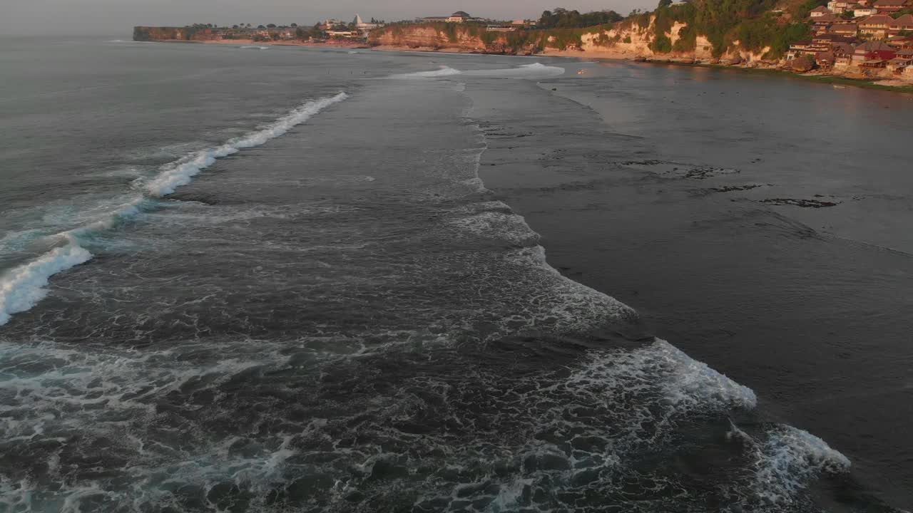 巴厘岛的海岸线、海浪和温暖的日落色调的鸟瞰图。视频素材