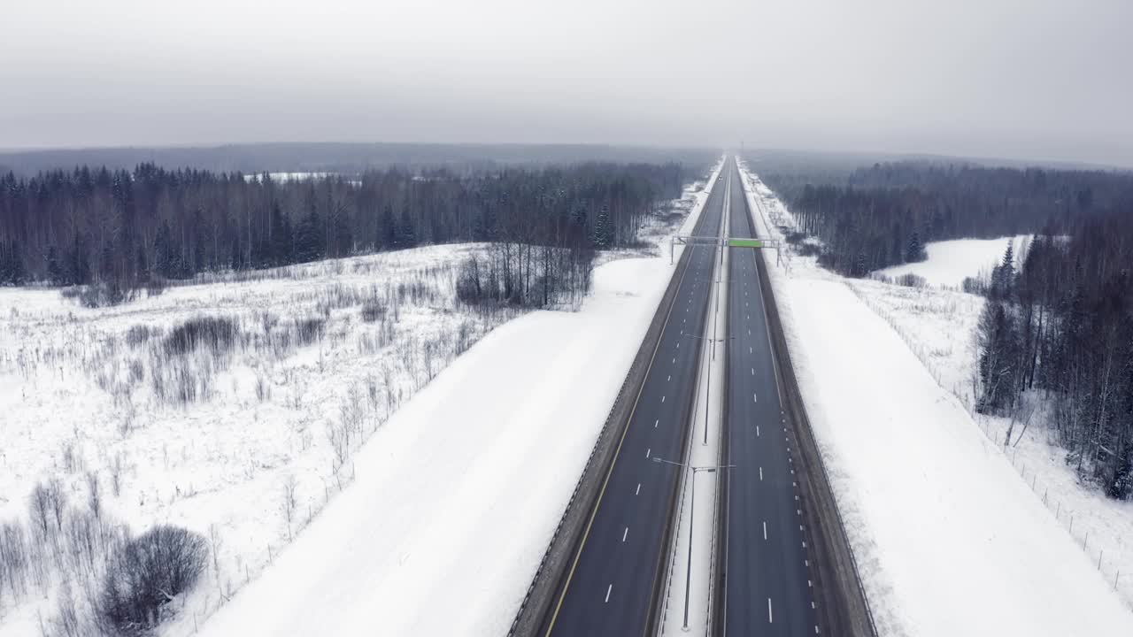 一辆白色卡车行驶在积雪覆盖的树林中，经过一个路标视频素材