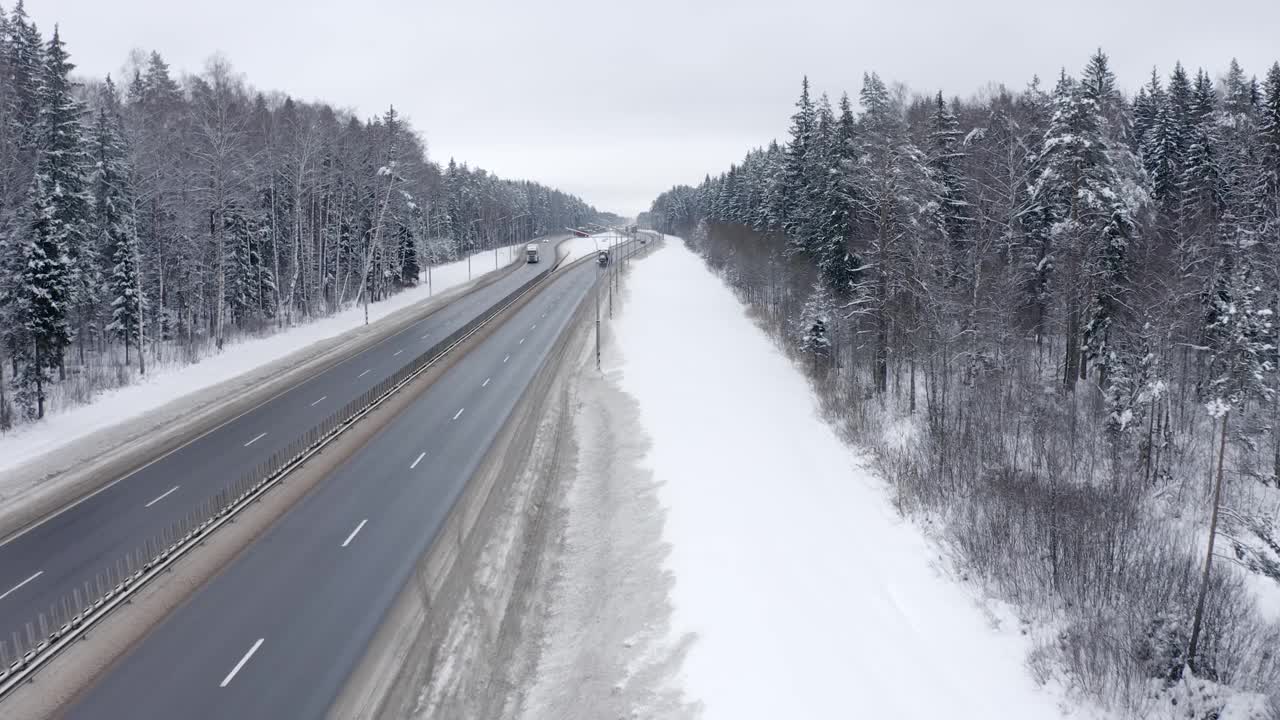 冬天，一辆白色卡车行驶在白雪覆盖的树林中。视频素材