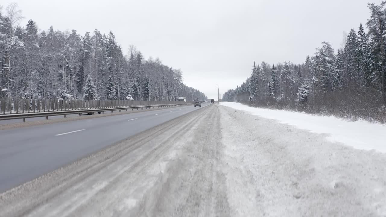 在白雪覆盖的森林中，公路上来往着大量的汽车和卡车视频素材