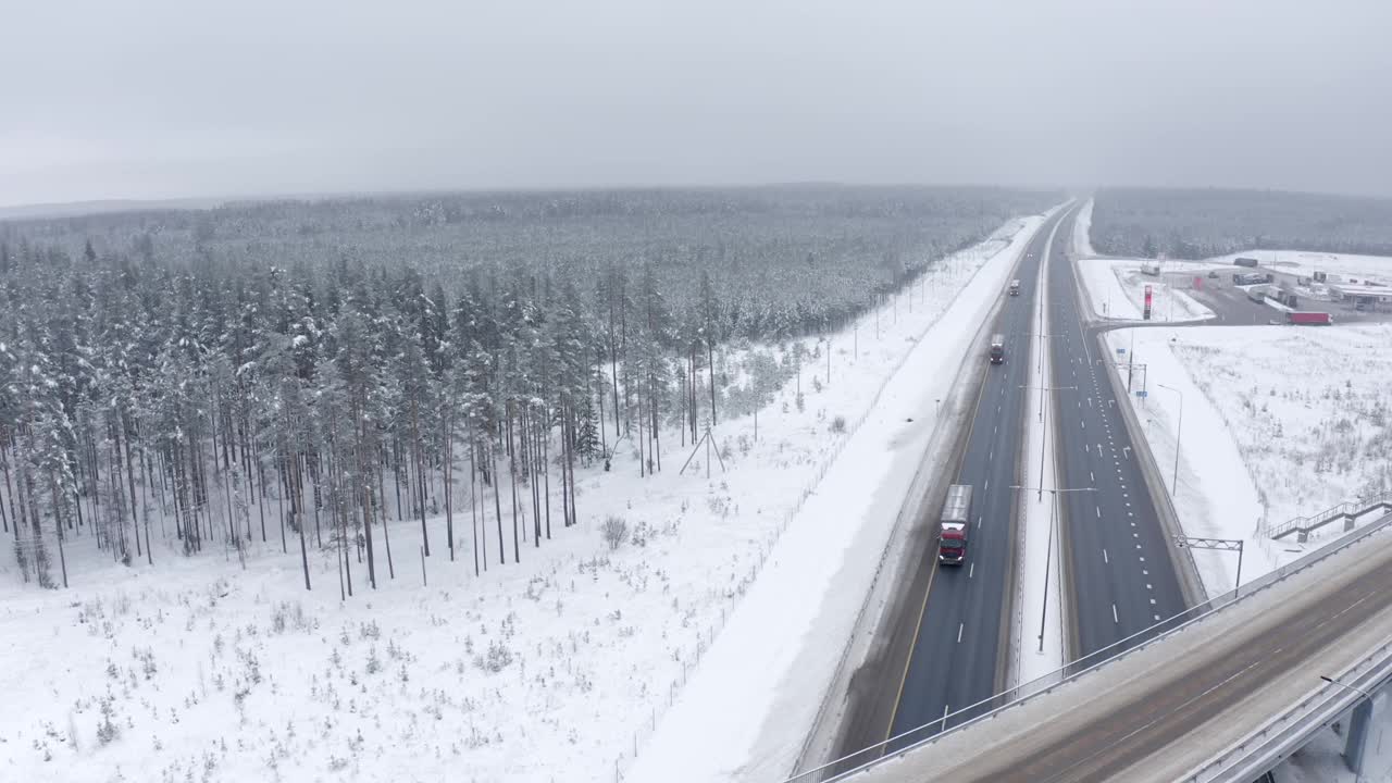 几辆卡车在路上行驶，树木被雪覆盖视频素材