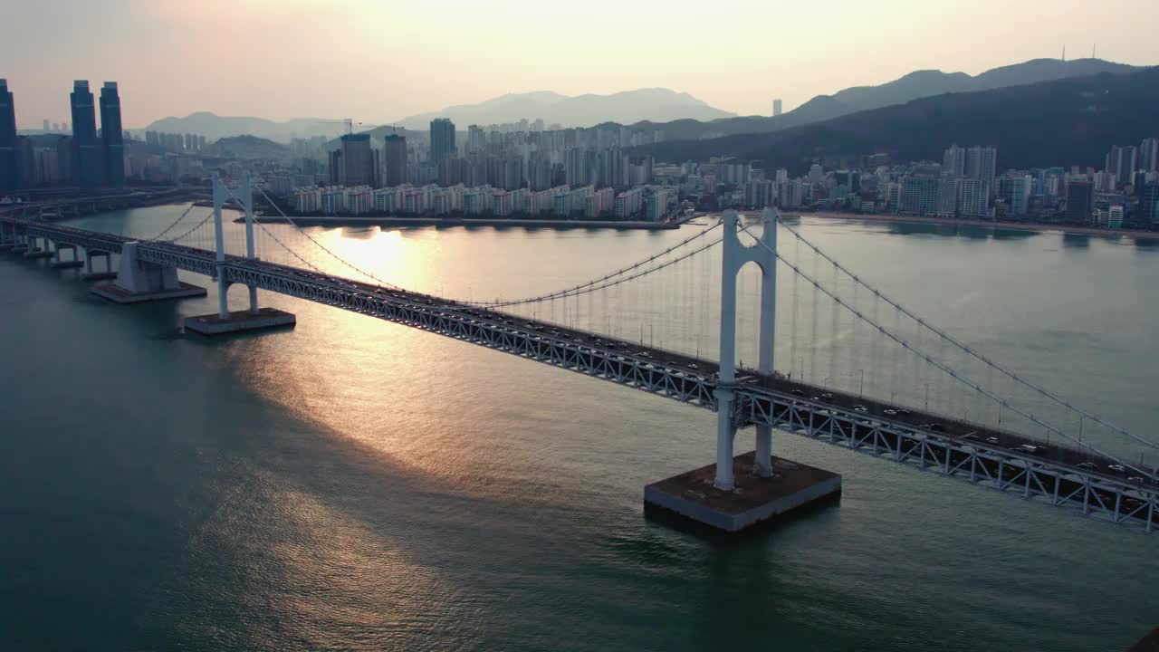 ▽日落=在釜山水永区海云台区市中心广阿里海滩的广安达桥上行驶的汽车视频素材