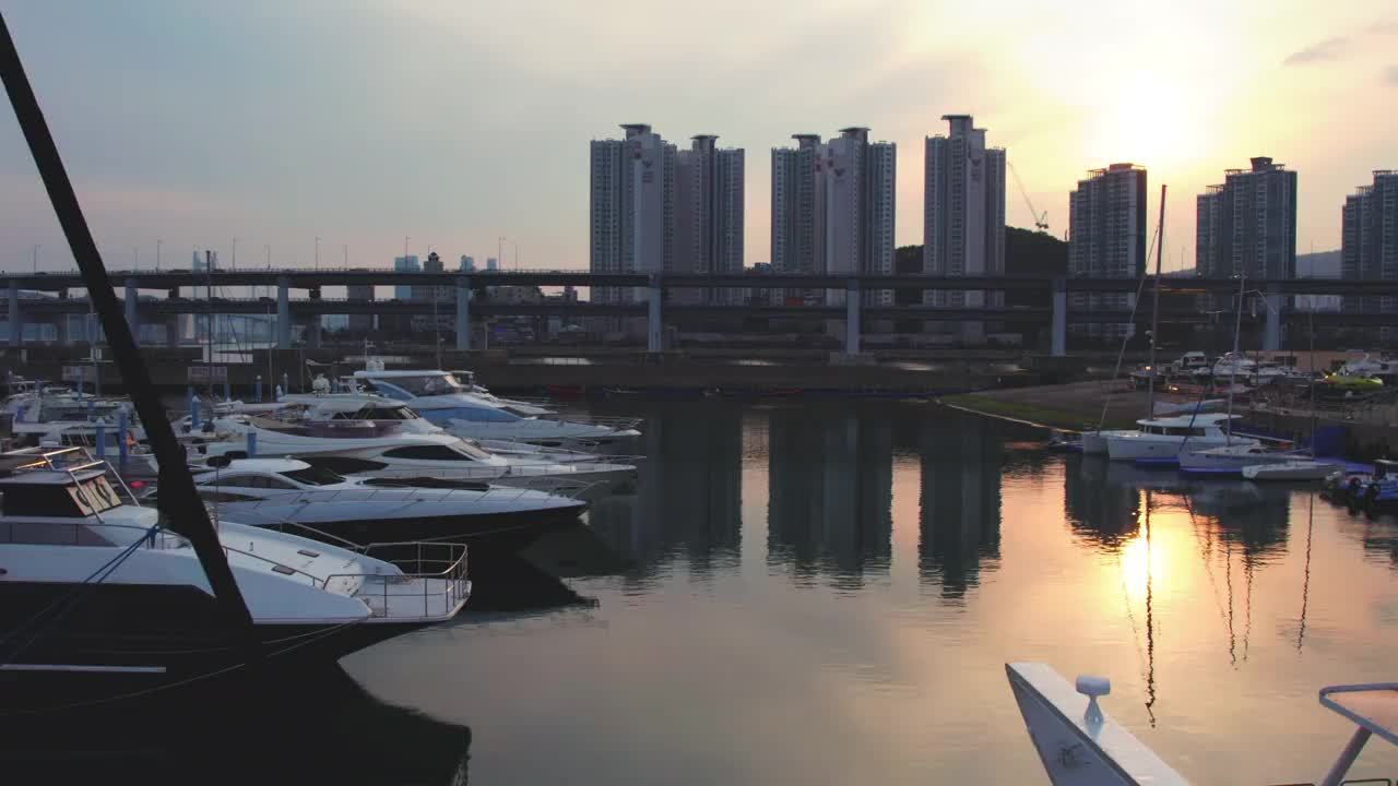 日落-在韩国釜山水永区海云台区广安德桥和游艇奥林匹克体育场附近行驶的汽车视频素材