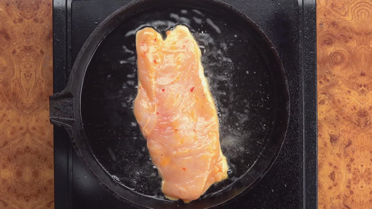 俯视图的一半准备卤汁鸡肉片翻转在烧烤锅视频素材