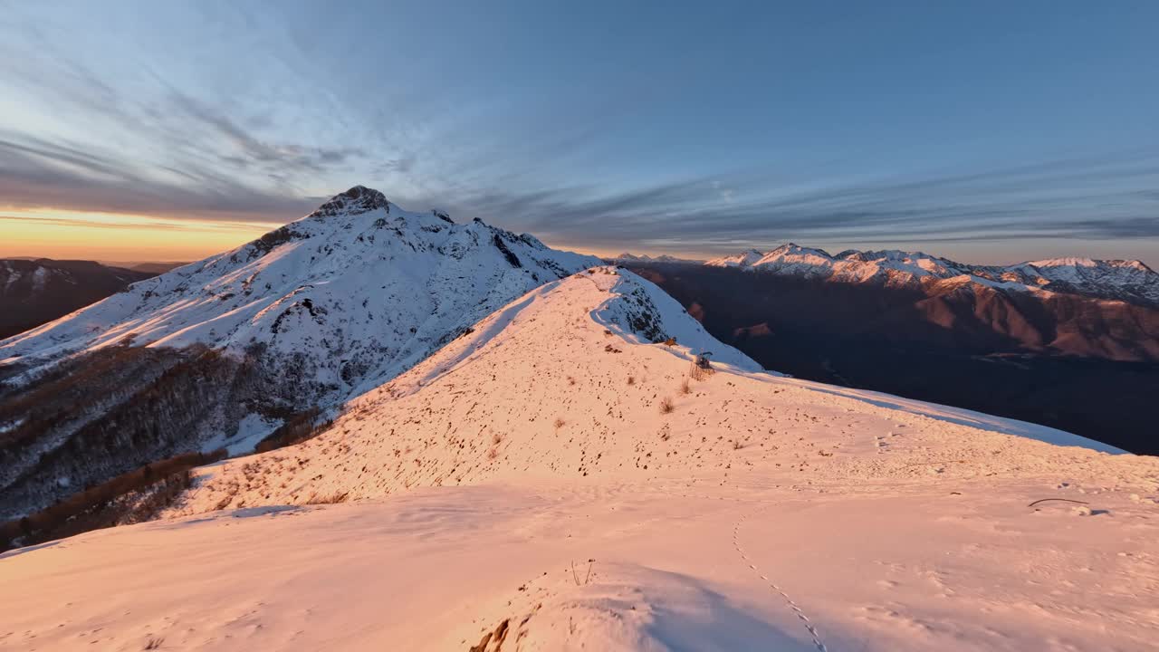 鸟瞰雪山山脊公路上美丽的金色日落日出。废票无人机视频素材