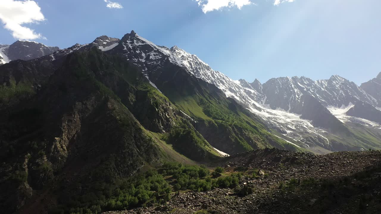 空中拍摄的山谷和阳光穿过巴基斯坦纳塔尔山谷的云层，史诗般的旋转无人机拍摄视频素材