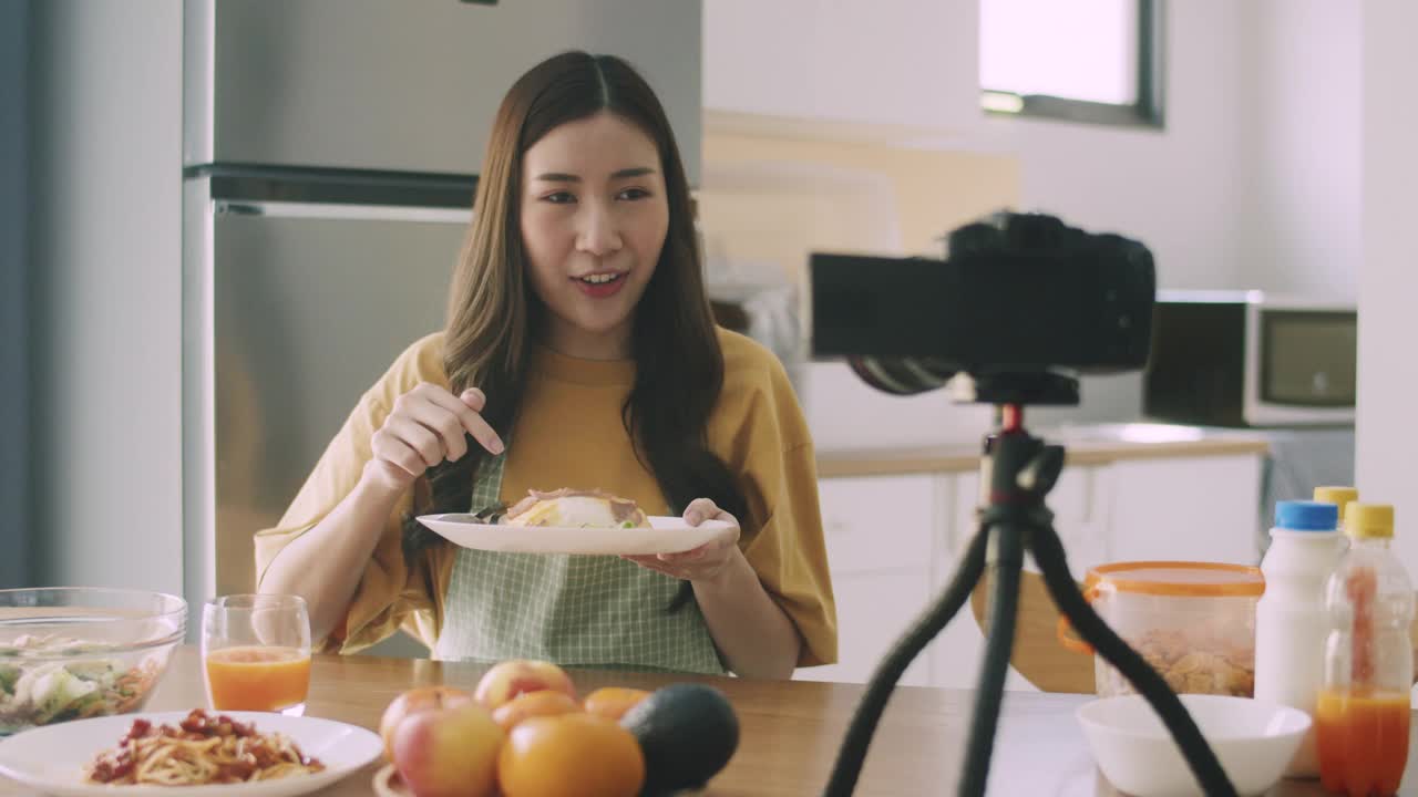 女博主有影响力的视频博主拍摄视频评论厨房里的食物和饮料。视频素材