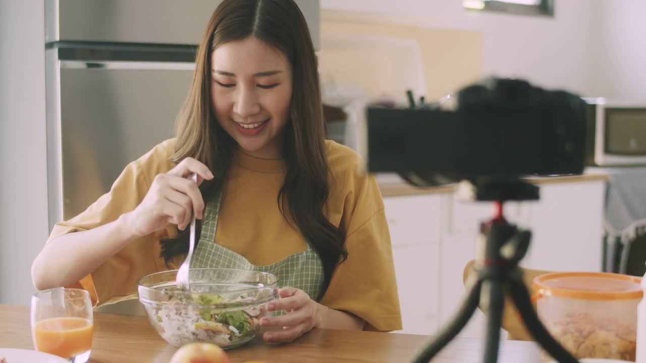 美女博主网红视频博主拍摄视频评论厨房里的食物和饮料。视频素材