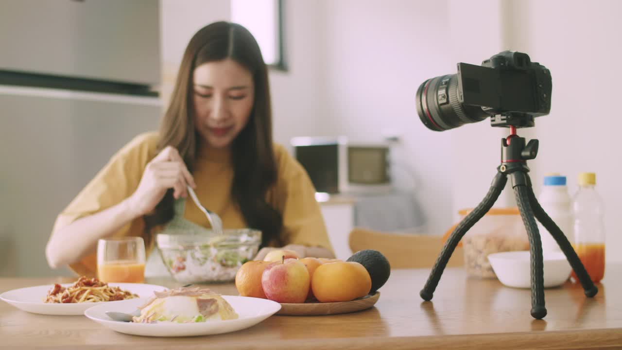 美女博主网红视频博主拍摄视频评论厨房里的食物和饮料。视频素材