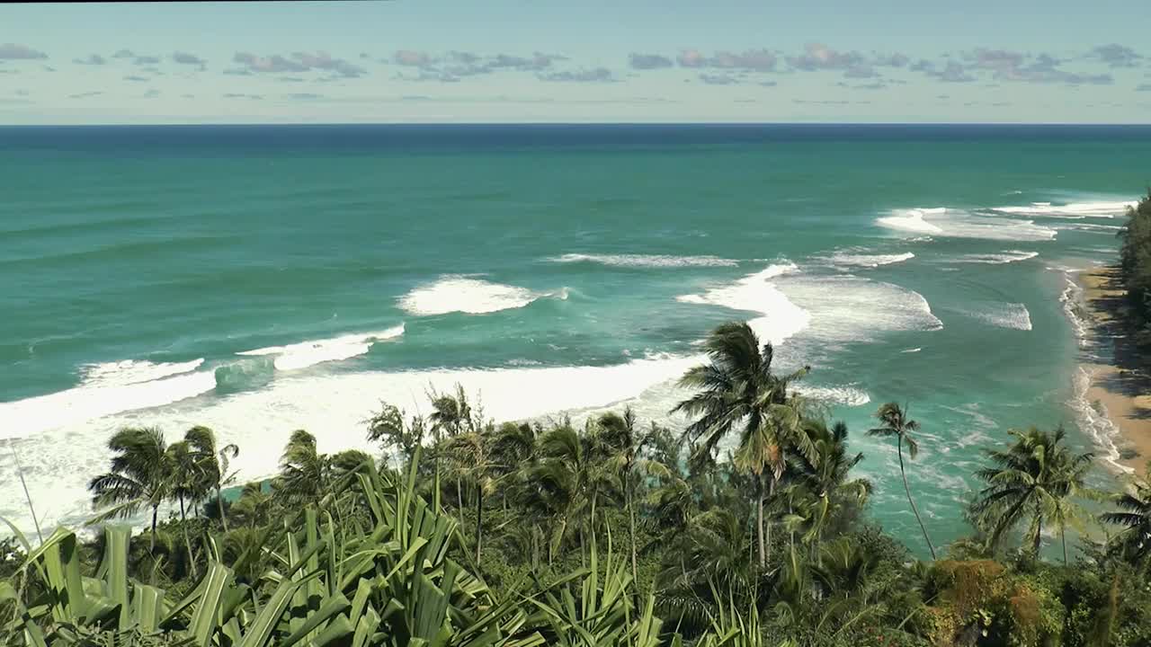 夏威夷群岛的自然风光。美丽的海景。蓝色的海浪以慢镜头撞击着岩石。热带岛屿的野生自然。夏威夷海岸线上的落基山脉和悬崖视频素材