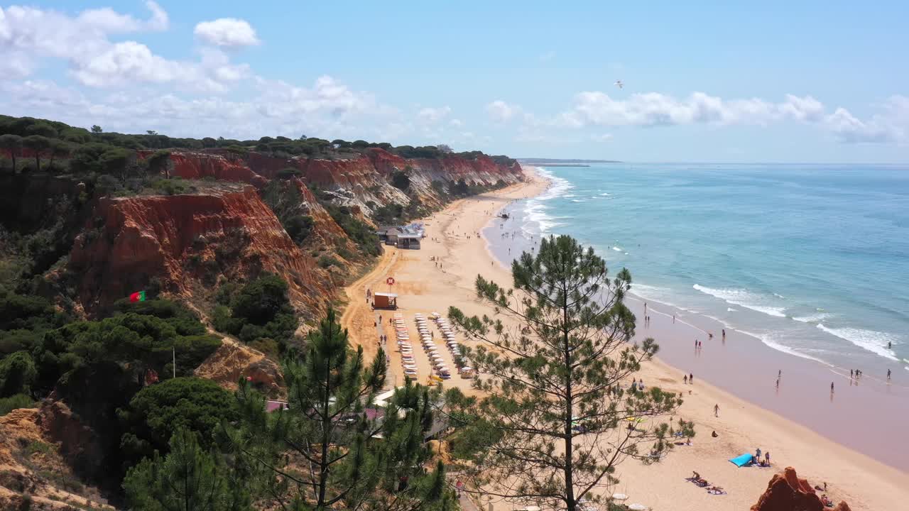 葡萄牙海滩与度假游客和自然的惊人的空中海景。Falesia海滩。无人机摄像头移动，右侧。视频素材