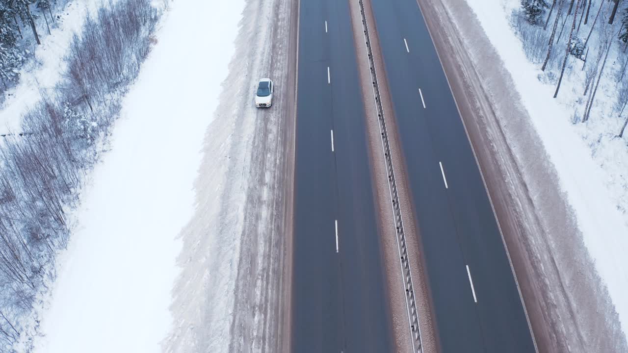 一辆白色的汽车停在白雪皑皑的路边，挂着应急灯，高速汽车在路上驶过，不停车视频素材