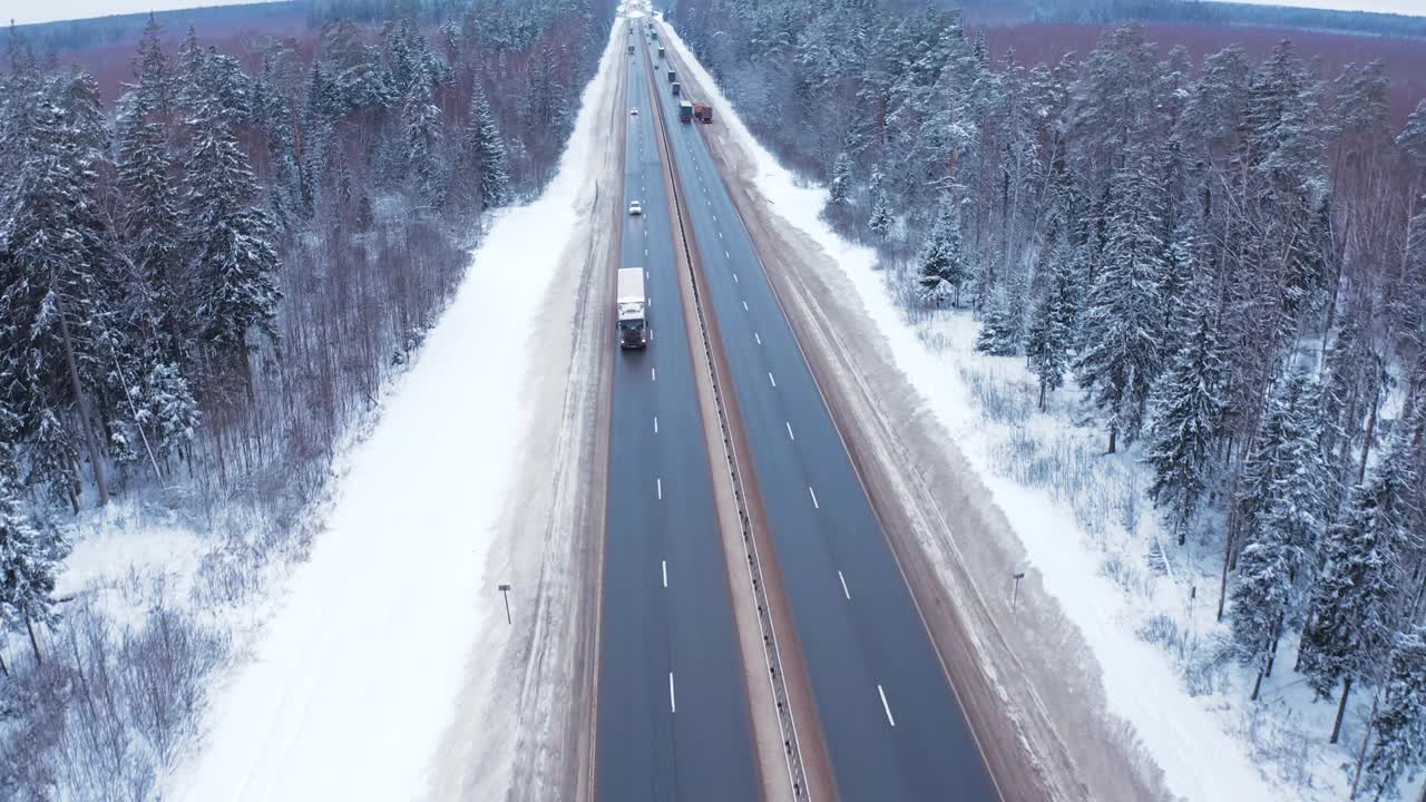 寒冷的冬天，一辆白色卡车行驶在白雪覆盖的树林中。视频素材