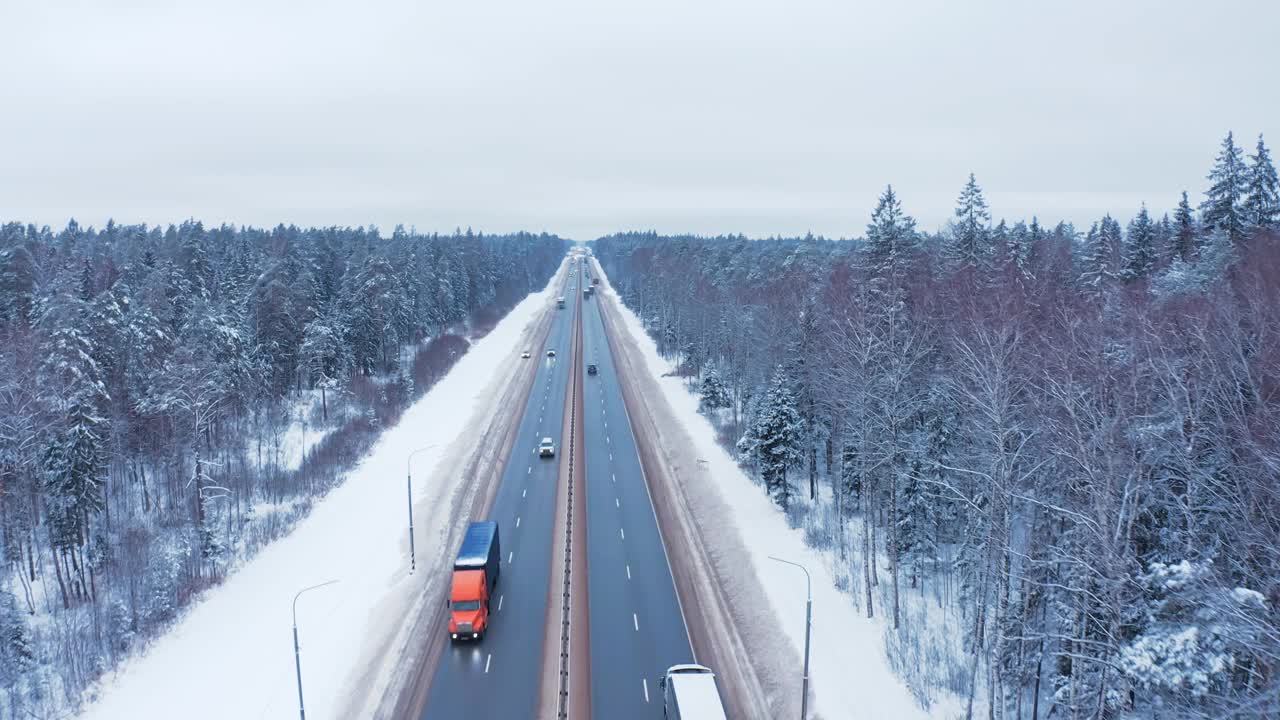 白色的货车、一辆卡车和一辆轿车正行驶在积雪覆盖的树林中视频素材