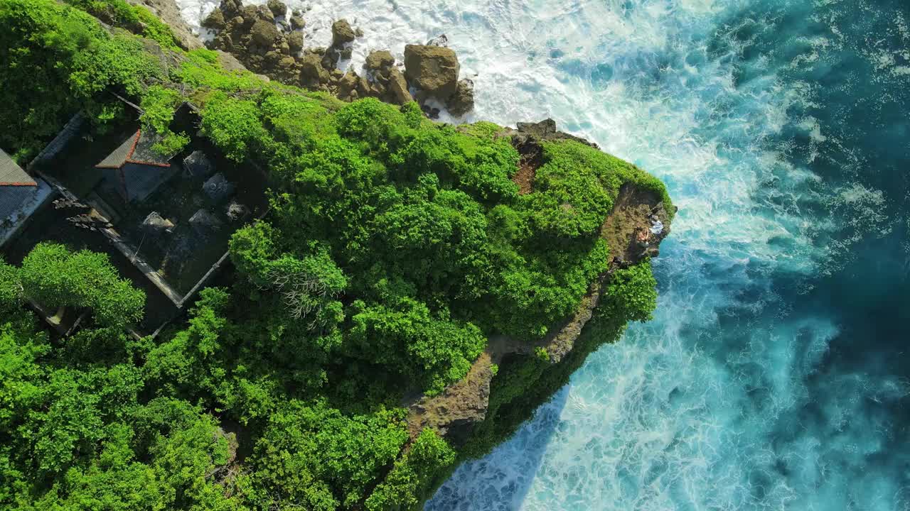 鸟瞰岩石海角与森林，巴厘岛寺庙和海洋与热带岛屿的波浪视频素材