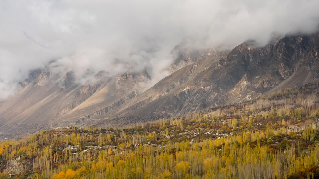 在巴基斯坦罕萨山谷的秋天，喀喇昆仑山脉雪山壮丽景色的时间流逝移动云日出场景视频素材