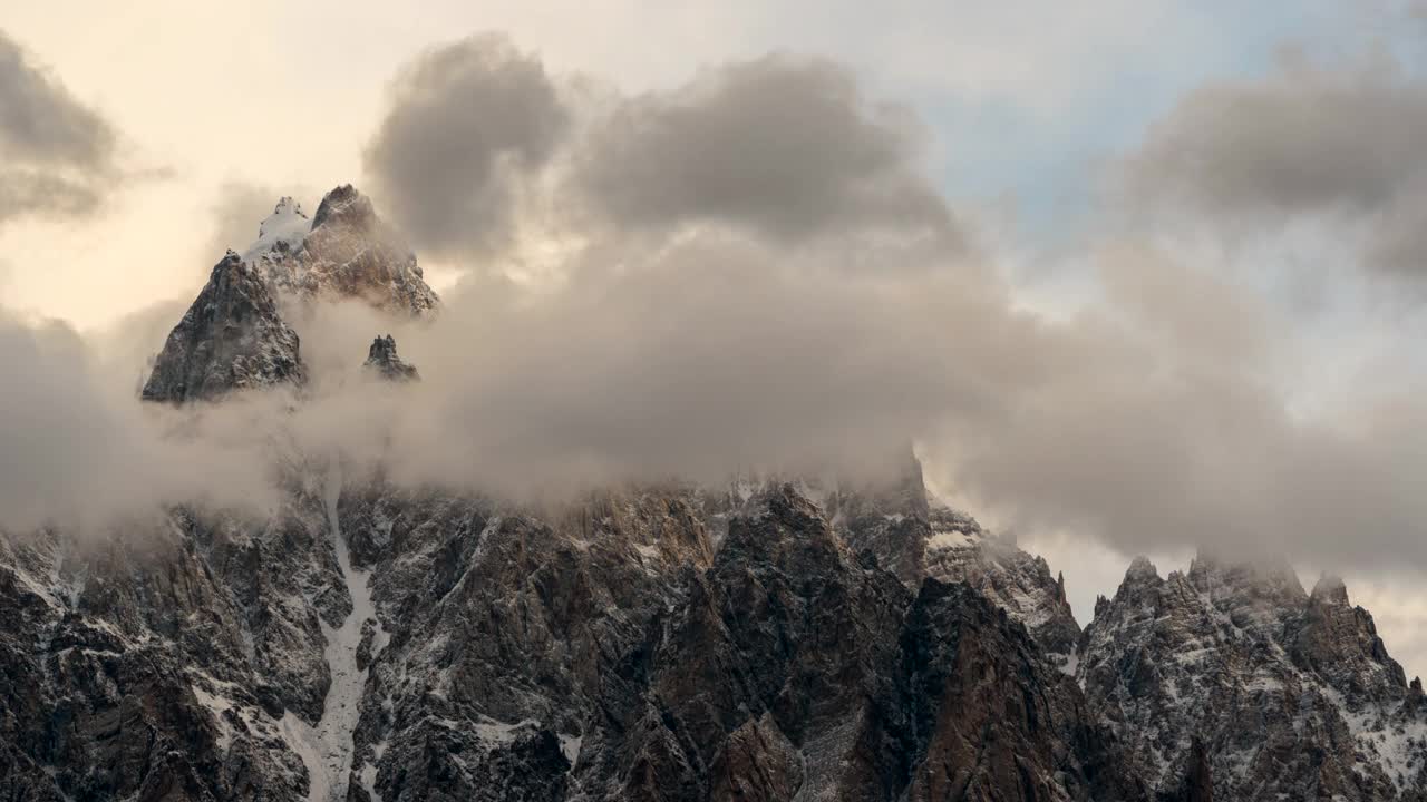 在巴基斯坦罕萨河谷地区的帕苏山谷，喀喇昆仑山脉雪山壮丽景色的延时移动云日出场景视频素材