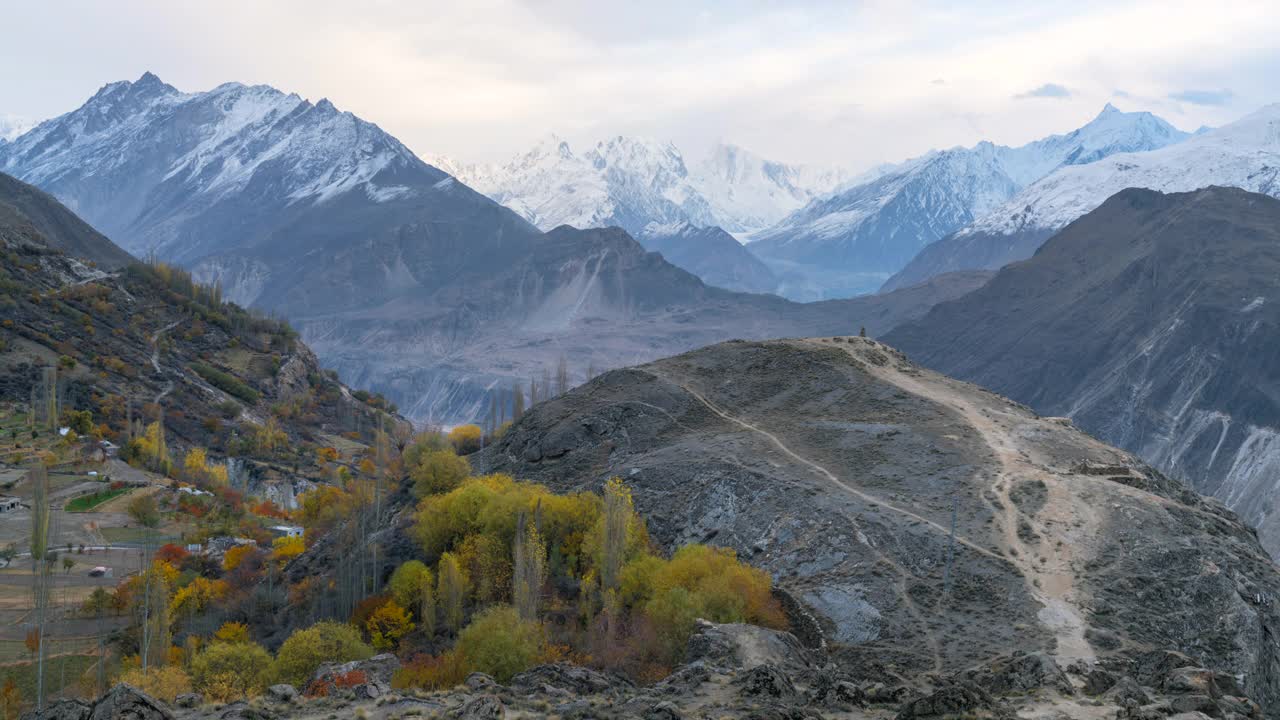 在巴基斯坦罕萨山谷的秋天，喀喇昆仑山脉雪山壮丽景色的时间流逝移动云日出场景视频素材