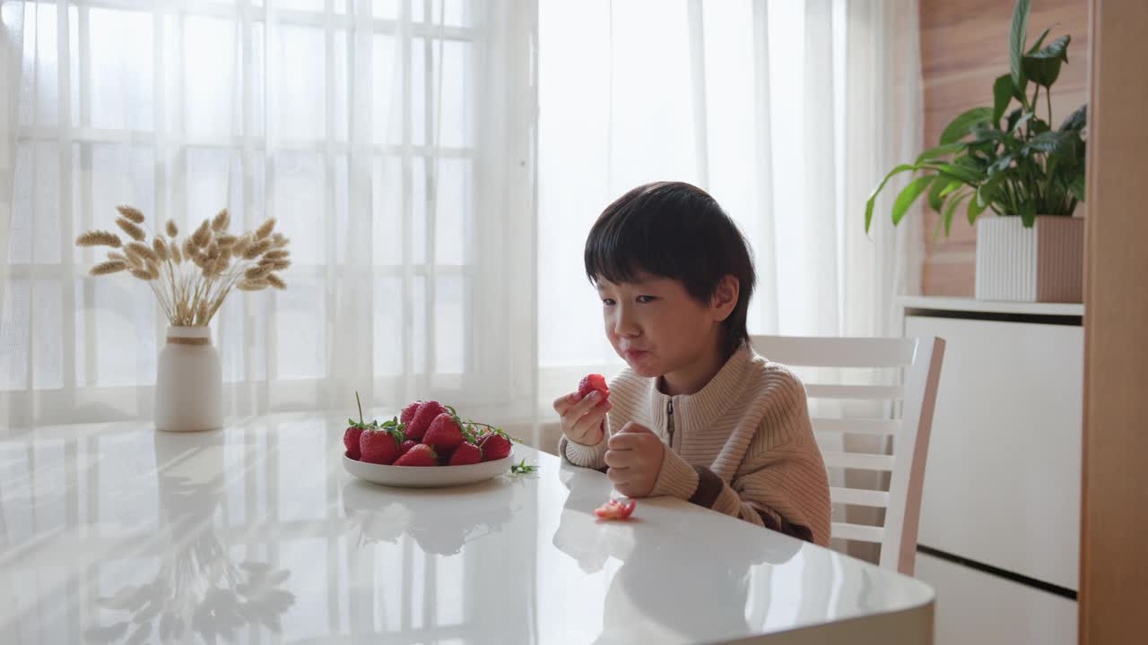 亚洲男孩吃草莓视频素材