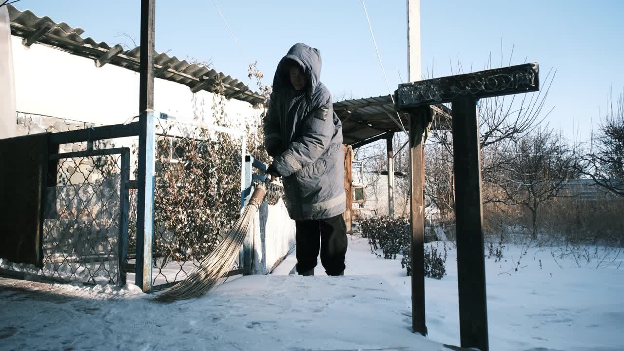 女人在后院扫雪视频素材