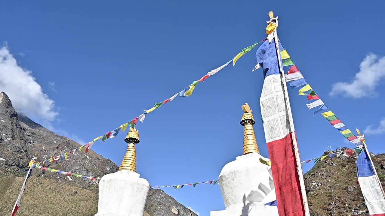 在尼泊尔昆布地区最大的夏尔巴人村庄Khumjung村的白色佛塔上，迎风飘扬的经幡。视频素材