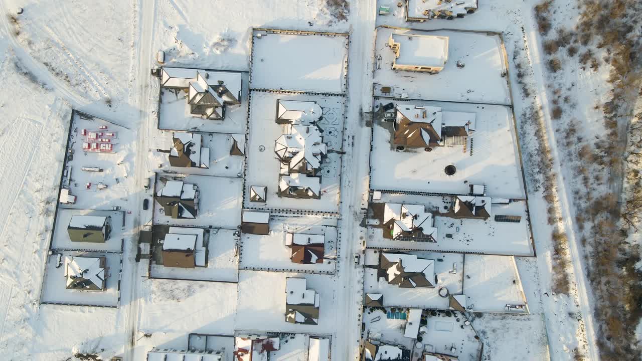 在寒冷的冬天，郊区郊区的私人住宅屋顶被雪覆盖的鸟瞰图视频素材