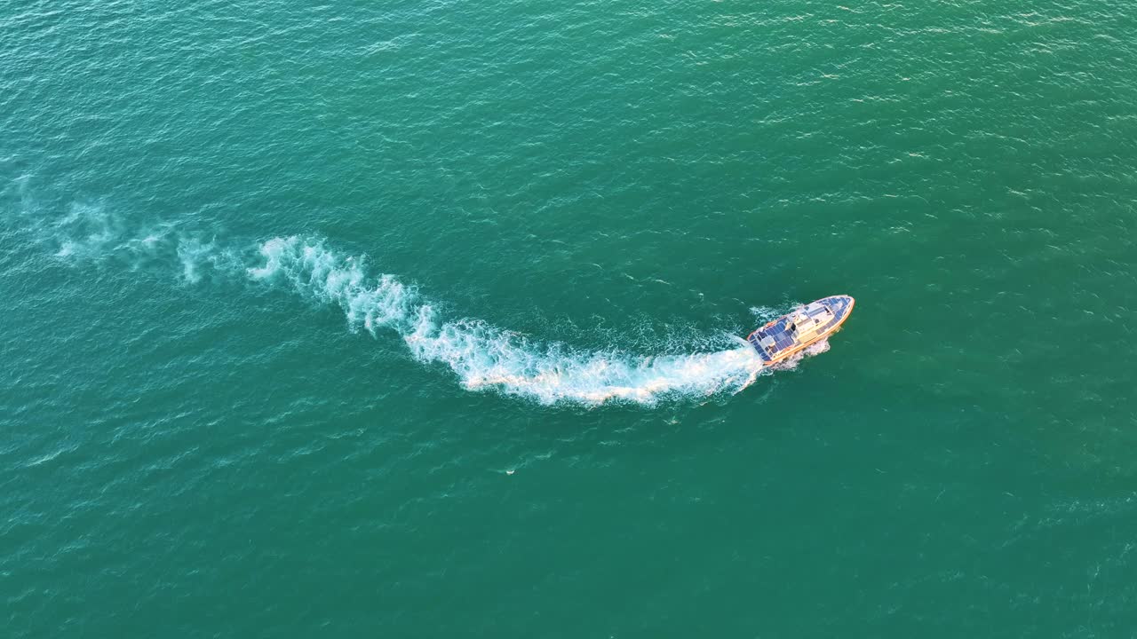 鸟瞰白色游艇游泳在海浪与波纹表面。在海洋上运动的摩托艇视频素材