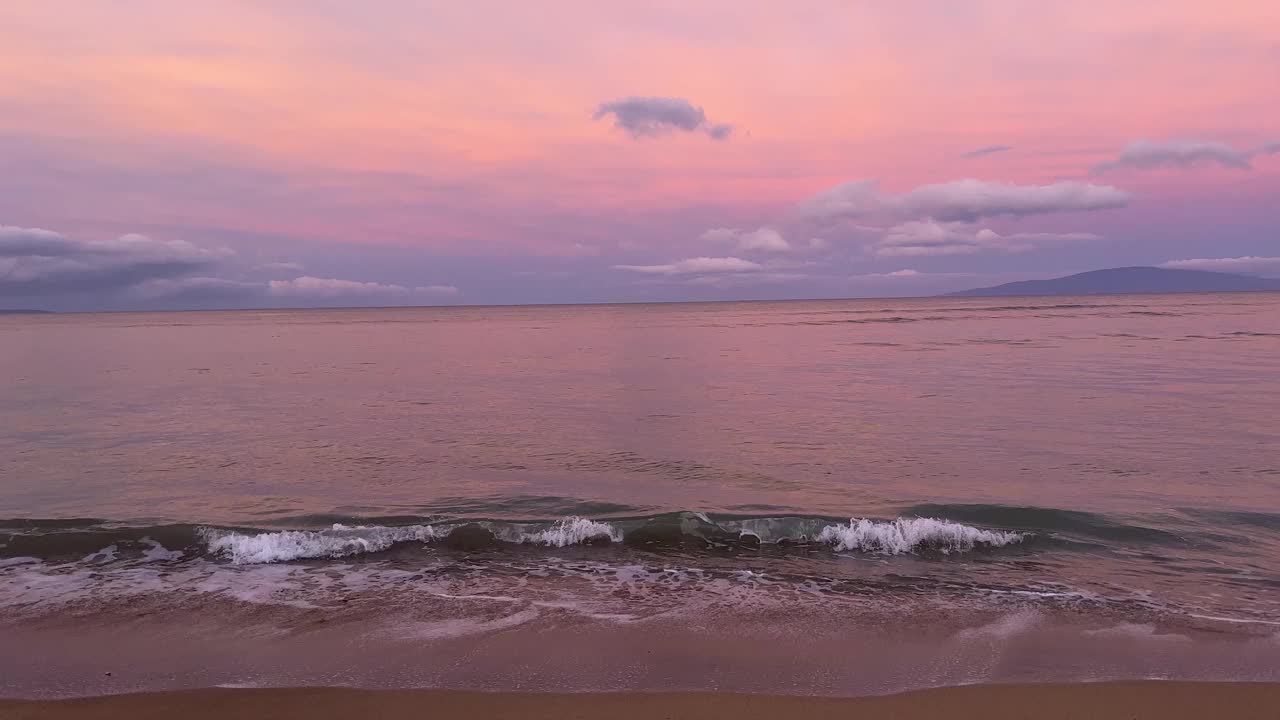 清晨的沙滩上，平静的海浪拍打着沙滩视频下载