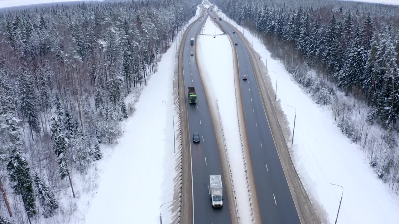 在白雪覆盖的森林中央，一辆空着车体的卡车正沿着道路行驶视频素材