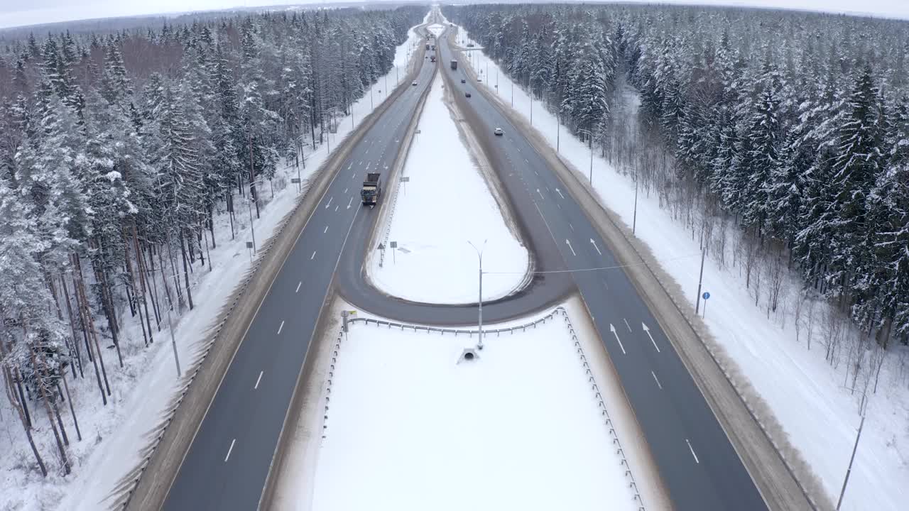 在白雪覆盖的森林中间，两辆路过的卡车的后视图视频素材