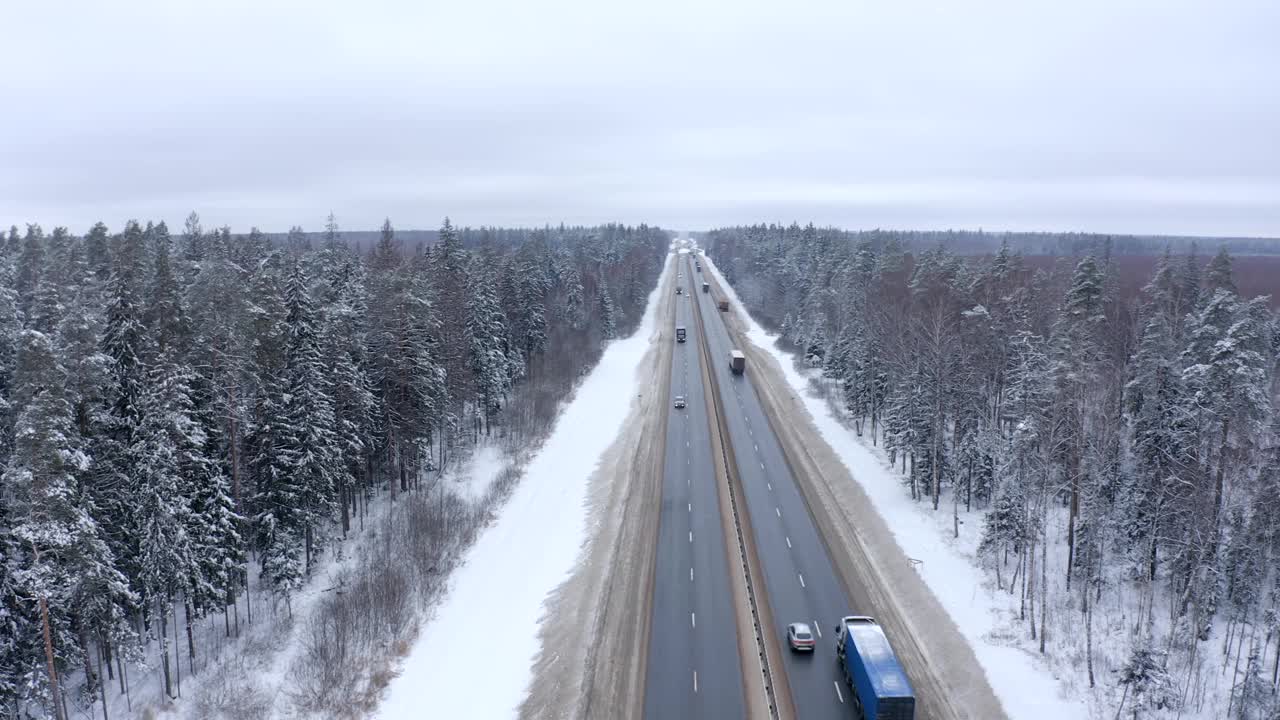 在冰天雪地的冬天，卡车沿着公路行驶。视频素材