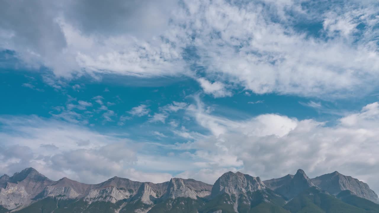 白云飘在岩石山上的蓝天上。时间流逝的云和天空在夏季天气好的天空。全景视频素材