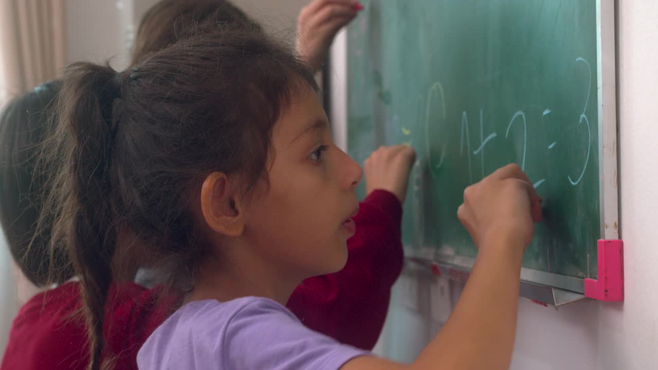 小学生把数学答案写在黑板上。视频素材