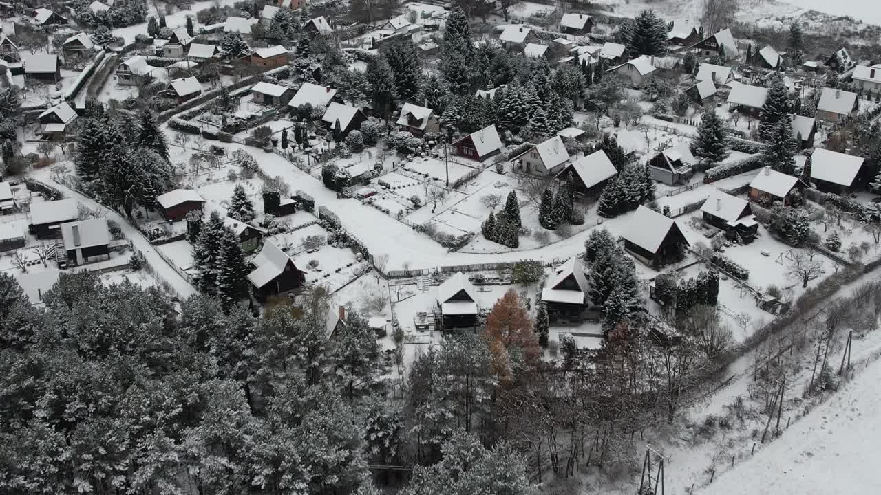 鸟瞰图宁静的小镇下厚厚的，新鲜的雪，初冬。大雪期间的乡村屋顶。郊区住宅小区冬日。欧洲波兰。视频素材