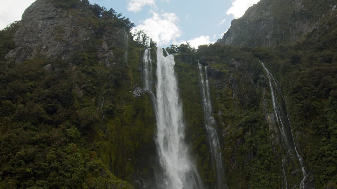 壮观的标志性景观，瀑布从米尔福德湾的山上流入海洋视频素材