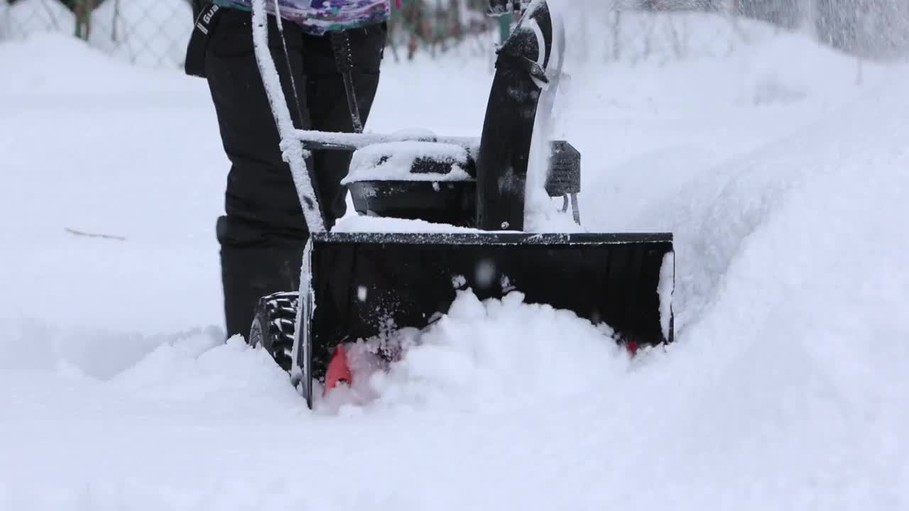 冬天,暴雪。缓慢的运动。用扫雪机清理这个区域。视频下载