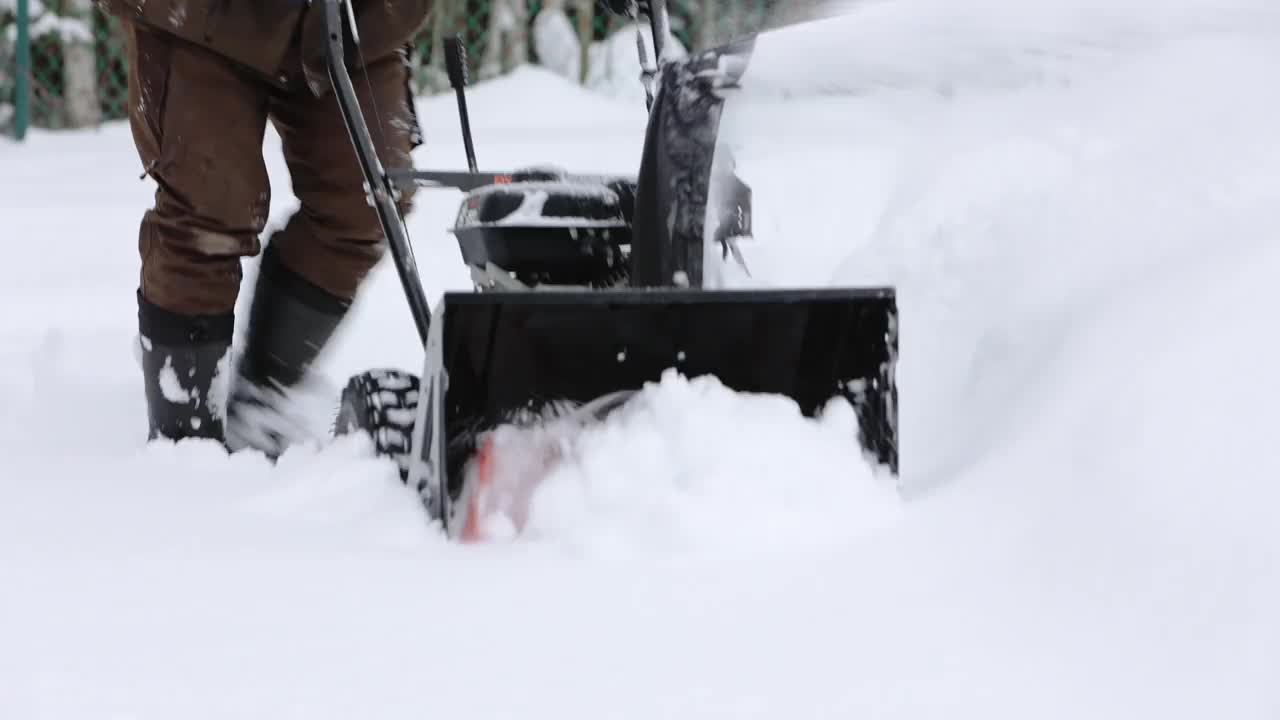 冬天,暴雪。用扫雪机清理这个区域。缓慢的运动。技术在不断进步。视频下载