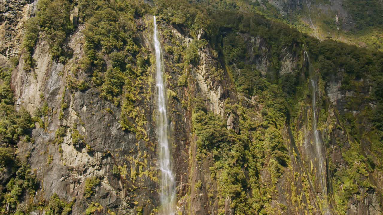 壮观的标志性景观，瀑布从米尔福德湾的山上流入海洋视频素材