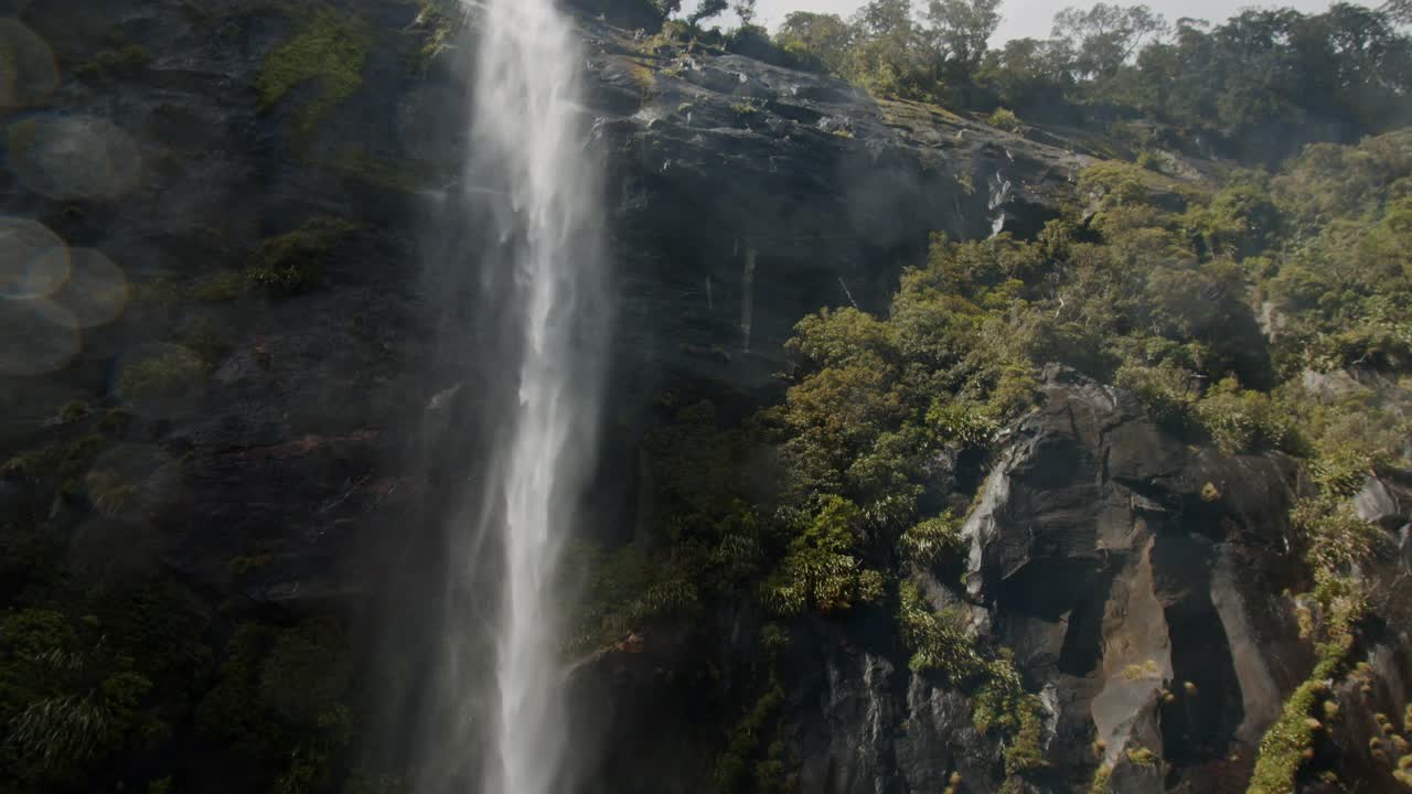 近距离观看从米尔福德湾的山上流入海洋的瀑布的标志性景观视频素材