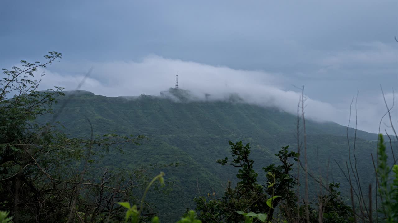 印度马哈拉施特拉邦辛格加德，西高止山脉的云雾翻滚，露出山顶上的一座塔视频素材