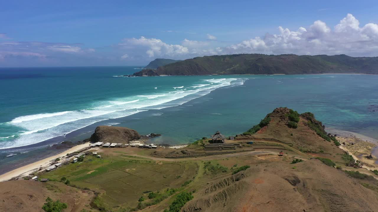 航拍风景的海浪飞溅向海滩，无人机飞越山地景观-龙目岛，印度尼西亚视频素材