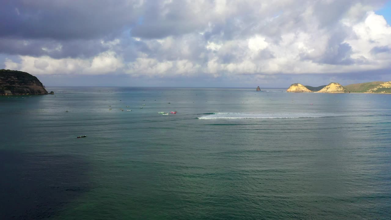 天空中云下的航海船只航拍风景，无人机在波涛汹涌的海洋上向前飞行-龙目岛，印度尼西亚视频素材