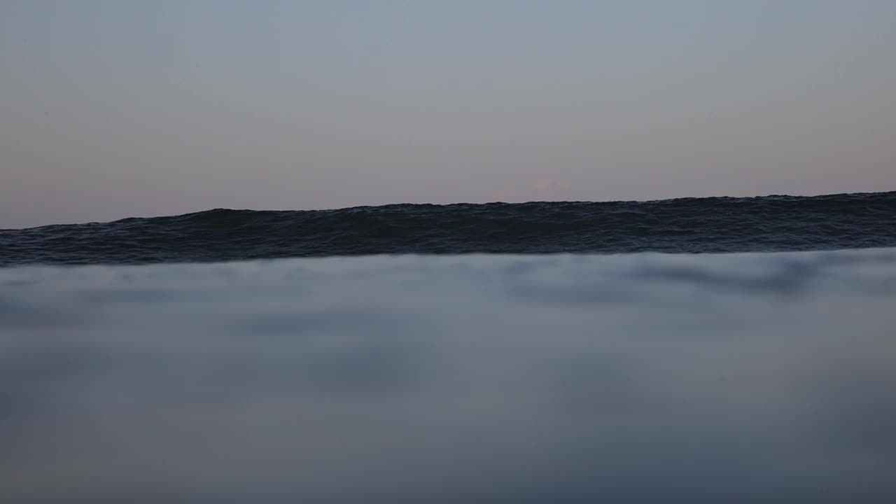 在日落期间，大海中的大浪与晴朗的天空的慢动作镜头——印度尼西亚龙目岛视频素材