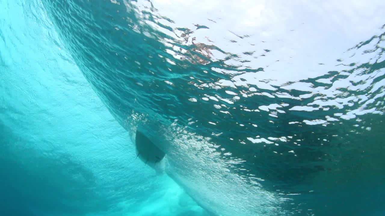 从海底看到的人在冒险度假冲浪的慢动作镜头——马尔代夫的thulushoo视频素材