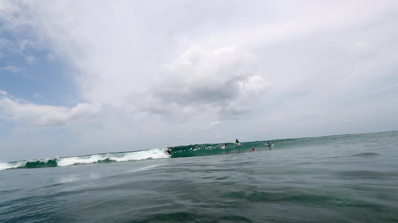 冲浪者在云层下的海浪上冲浪的慢动作镜头——马尔代夫的thulushoo视频素材