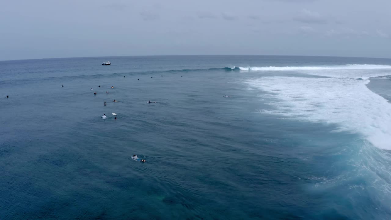 游客在度假时用冲浪板游泳的航拍，无人机在波浪般的海面上向前飞行-马尔代夫的thulushoo视频素材