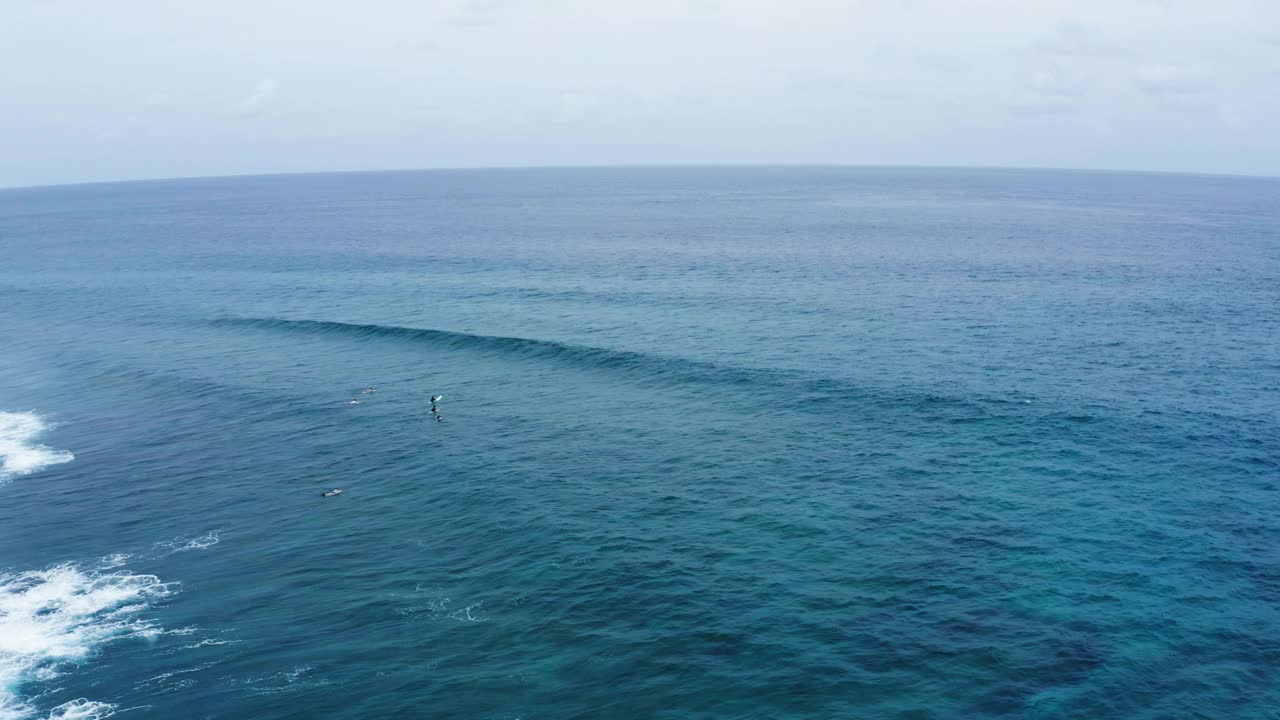 游客度假期间在海洋中冲浪的空中向后拍摄-马尔代夫的thulushoo视频素材