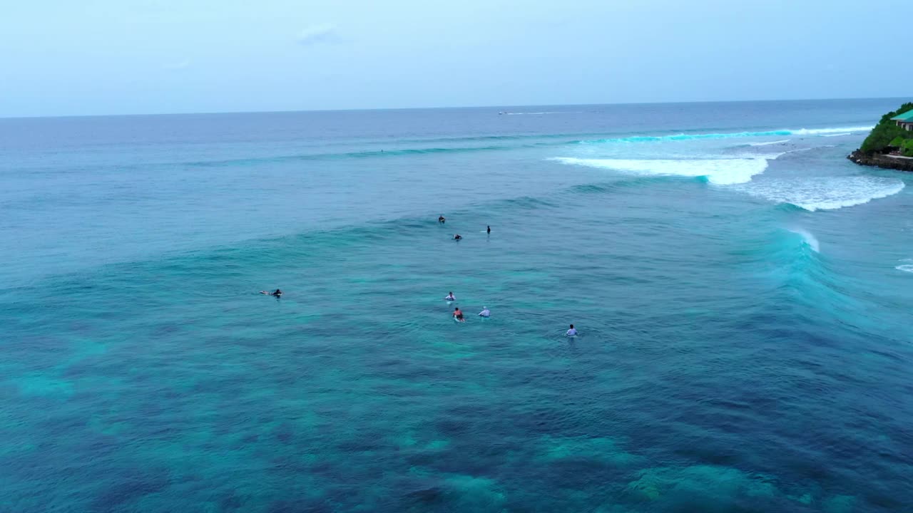 空中封锁拍摄的人们在度假期间在海上漂浮的冲浪板——马尔代夫的thulushoo视频素材