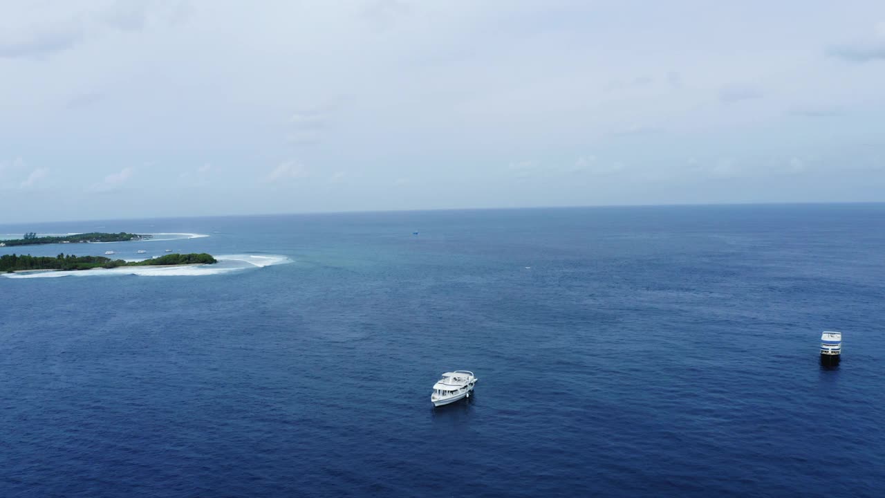 空中向前拍摄的白色航海船只漂浮在海上对着天空- thulushoo，马尔代夫视频素材