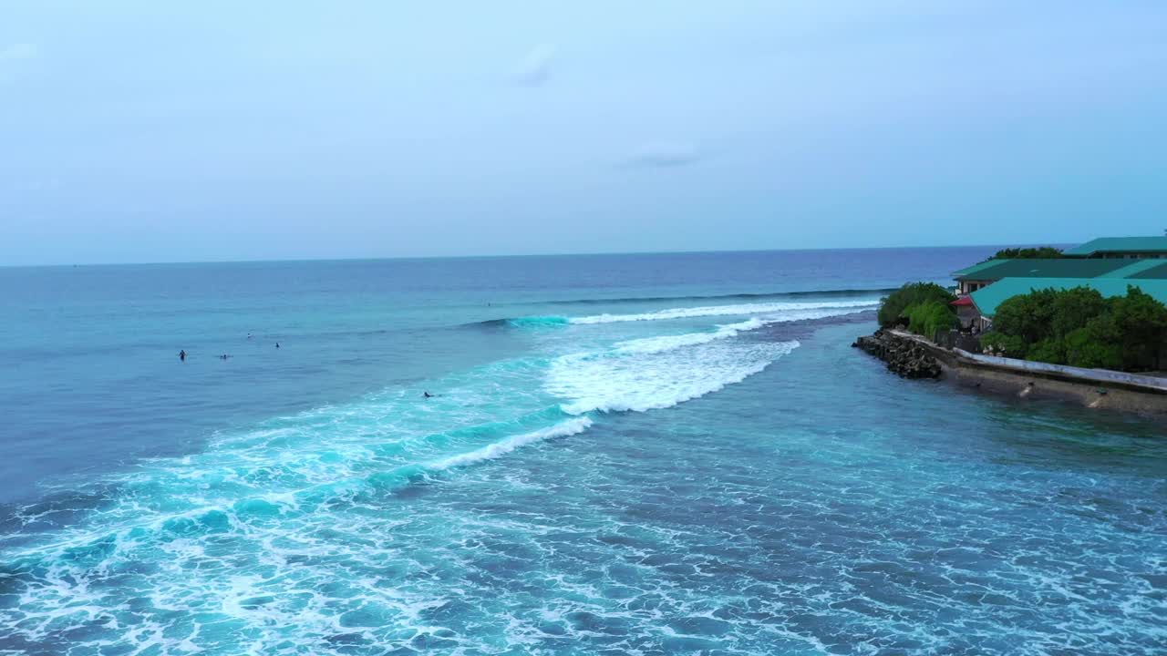 人们用冲浪板在波浪般的大海中游泳的空中前进镜头——马尔代夫的thulushoo视频素材